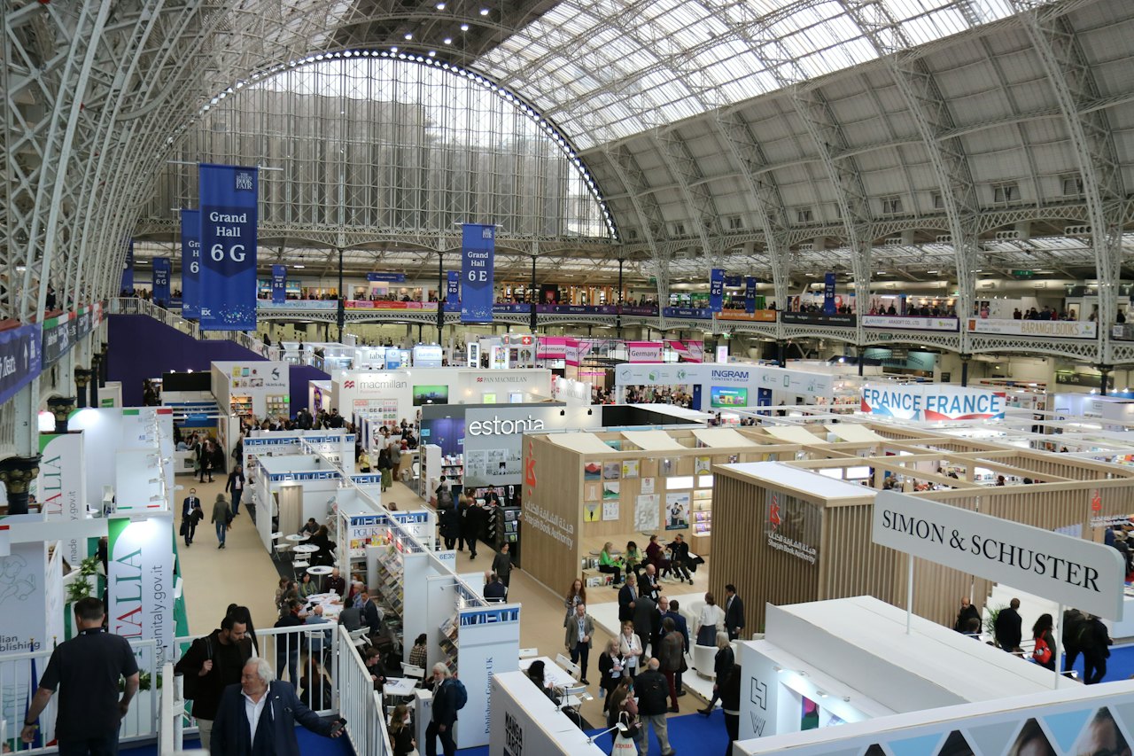 A busy exhibition hall filled with booths and attendees