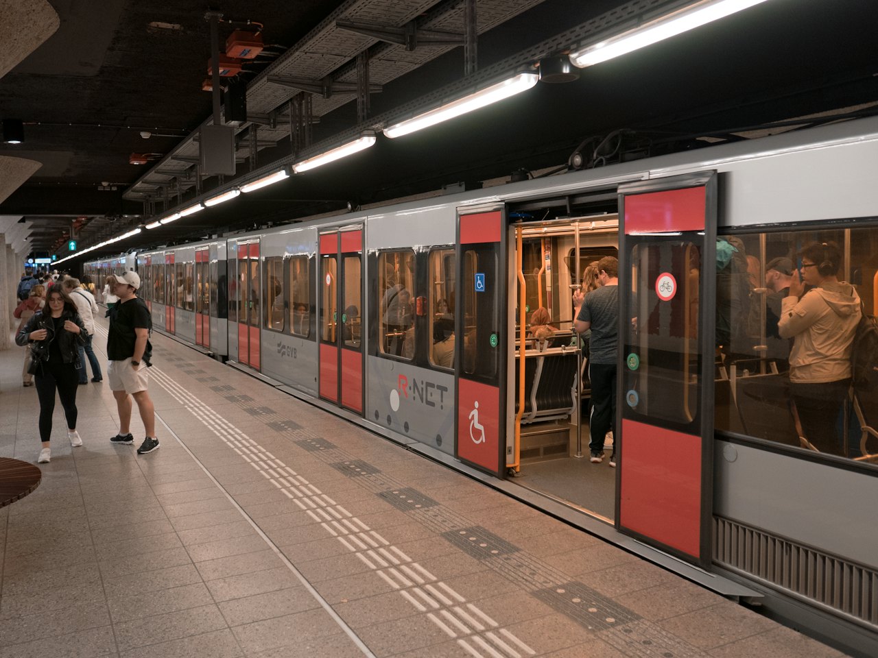 Commuters on a metro platform beside a train