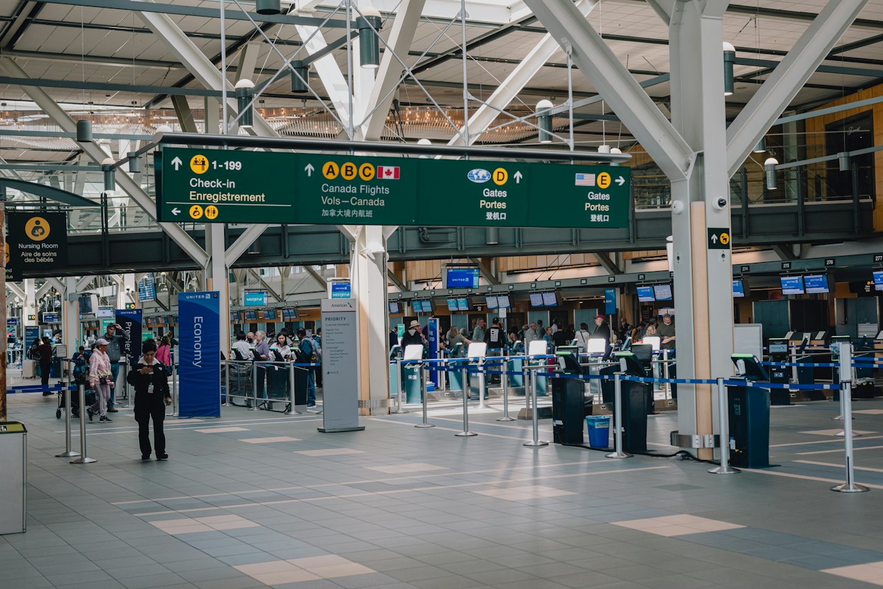 Travellers moving through a busy airport terminal